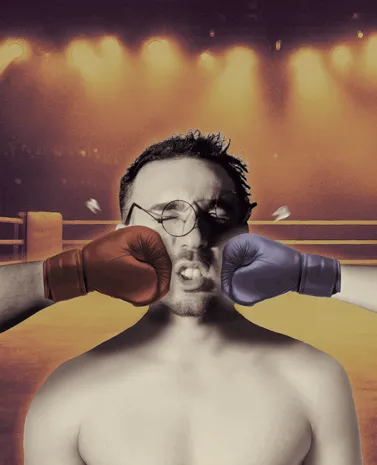 A man in the ring between two boxing gloves
