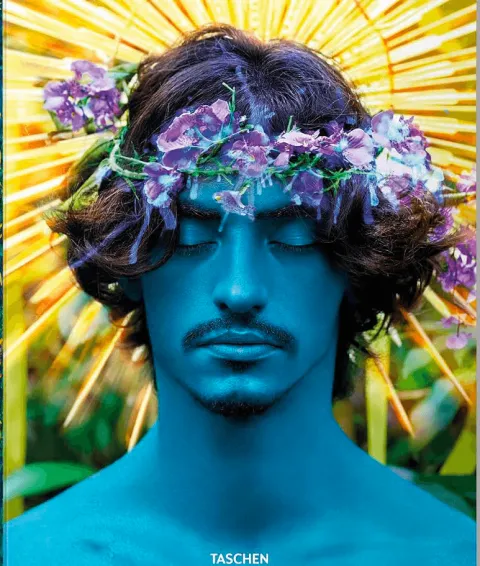 A David LaChapelle portrait: a blue face crowned with flowers