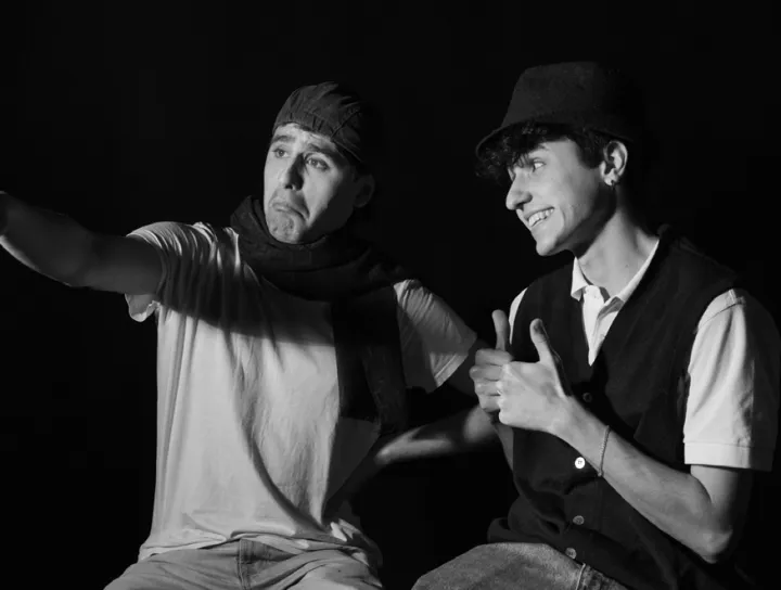 Early test: two men pointing, photographed against black