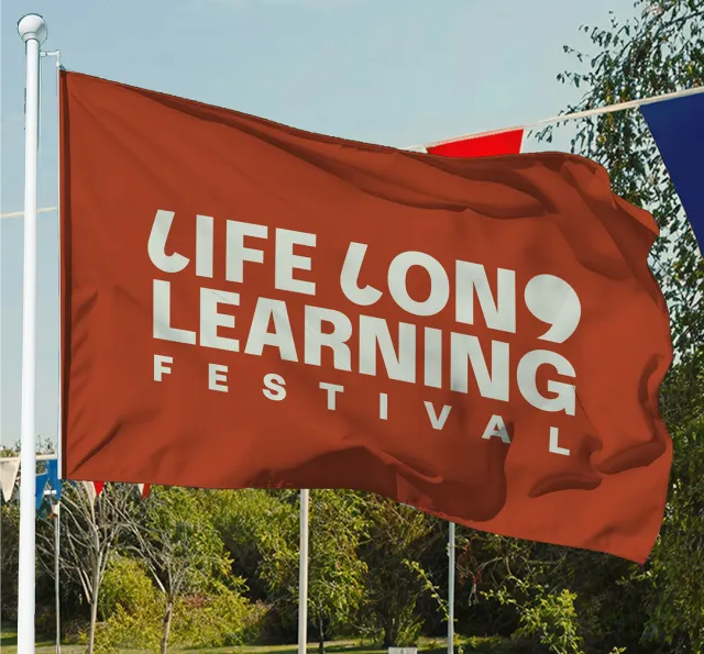The Lifelong Learning Festival flag flying in a park