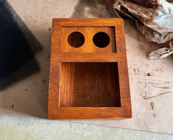 The stained box with the face on, before the speaker goes in