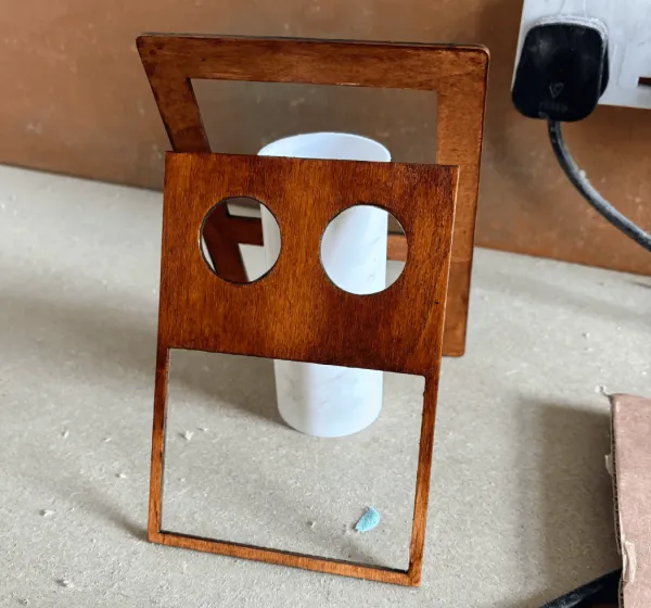 The face panel with the two eye holes cut, standing on the bench