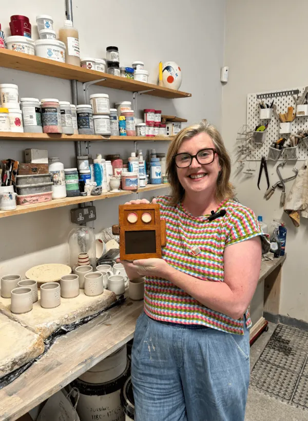 A ceramicist holding the Lugh dock in her studio