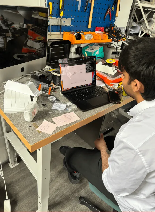A tester at a workbench with the dock and a laptop