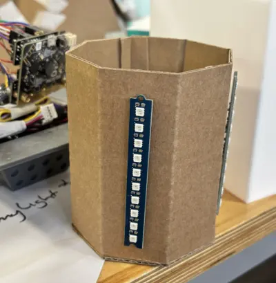 Cardboard octagon mock-up with an LED strip taped to one face