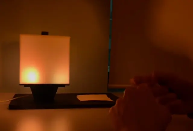Hands crumpling the paper into a ball, NOX glowing behind them