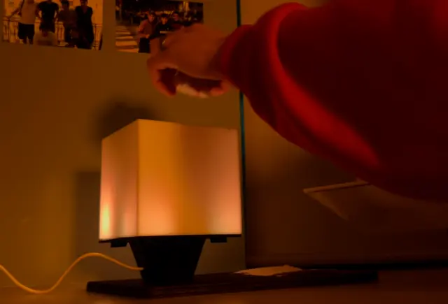 A hand holding the crumpled ball directly above the open top of NOX