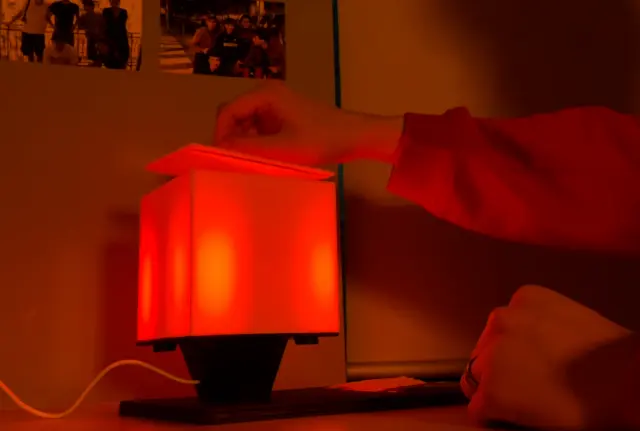 NOX burning bright red, filling the room with colour as the hand withdraws