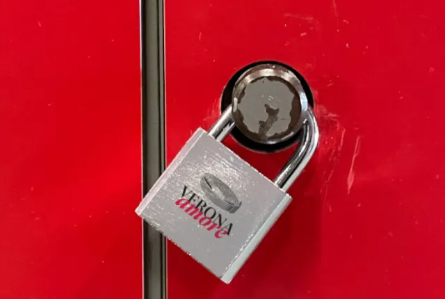 A silver love lock engraved with Verona Amore, on a red door