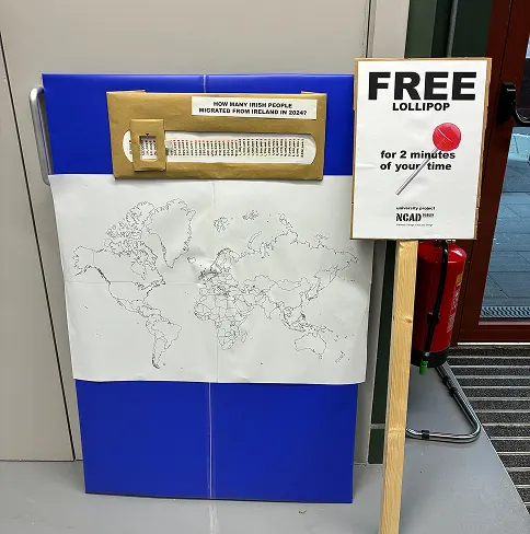 The probe: an emigration number slider above a world map, next to a “Free lollipop for 2 minutes of your time” sign
